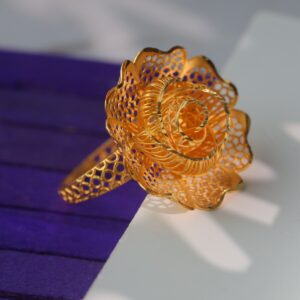 The circular arrangement of the flower on the ring is open on the top, forming a unique and remarkable three-dimensional look that was modeled after the appearance of a rose at different stages of bloom. The petals of the flower’s enchantment feature strands of wires that are intricately arranged, while the body shines in rich gold tones that are plush. Alternatively, as a signature statement, this Kuwaiti Gold Ring will complement any style or look effortlessly.